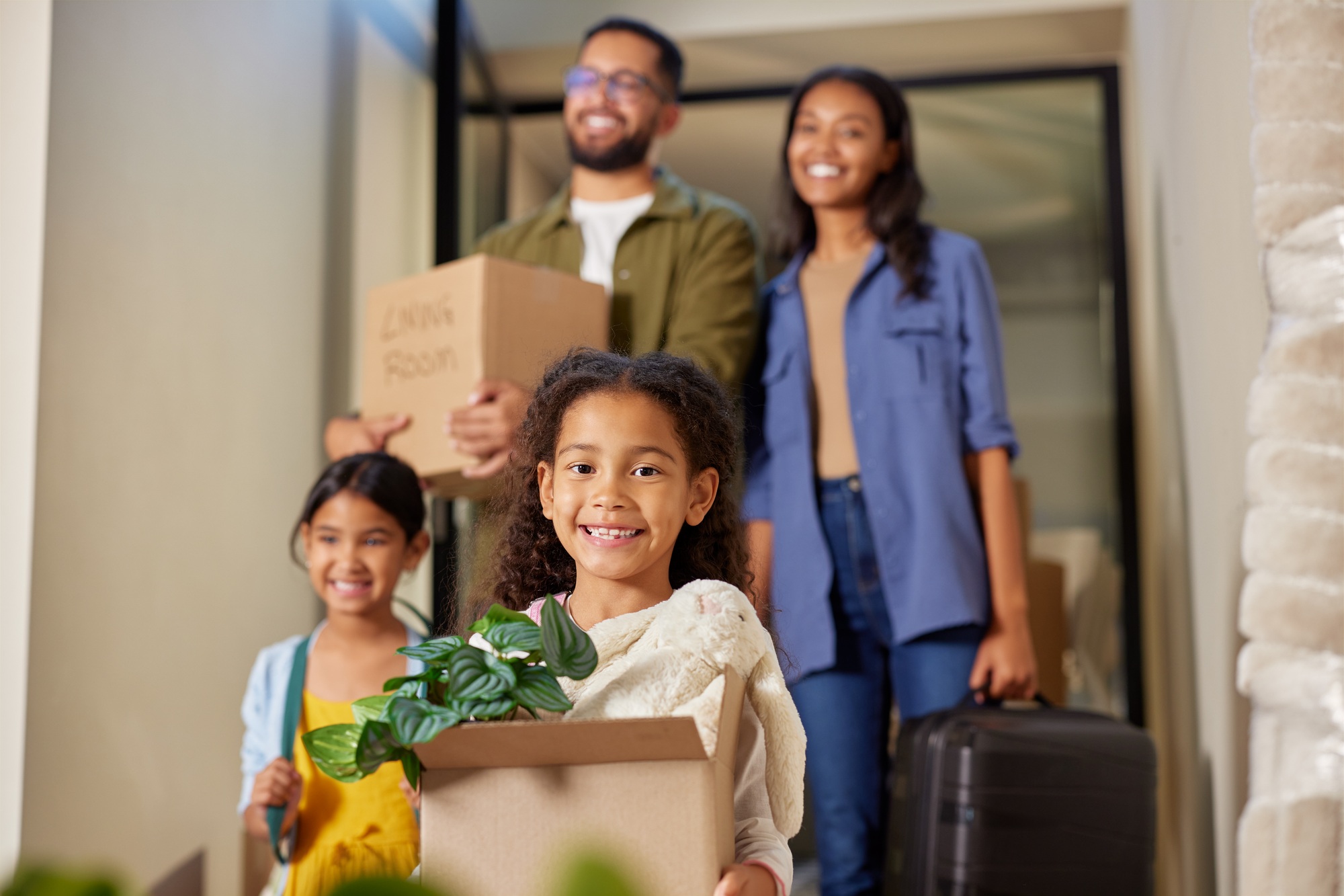 Family moving in with cardboard boxes in new house